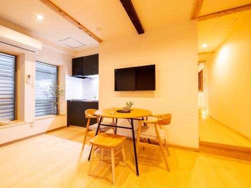 a kitchen and dining room with a table and chairs at ひとあかり 東山 Hitoakari Higashiyama-A Warm and Modern Machiya Stay in Shimmachidōri