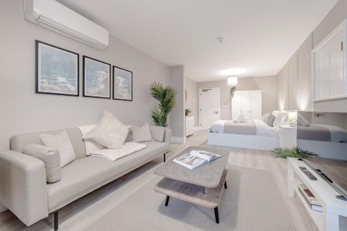 - un salon blanc avec un canapé et un lit dans l'établissement Silver Birches by MCF, à Redhill
