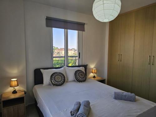 ein Schlafzimmer mit einem großen weißen Bett mit einem Fenster in der Unterkunft Horizon View 2 in Kiti