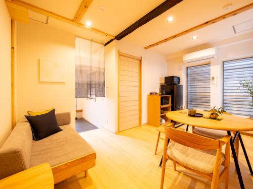 a small living room with a table and a couch at ひとあかり 東山 Hitoakari Higashiyama-A Warm and Modern Machiya Stay in Shimmachidōri