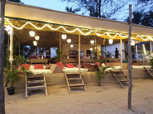 帕特南Mountain Palm patnem beach的沙滩上的帐篷，下面有床。