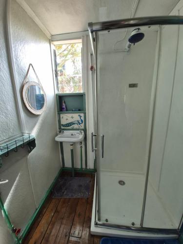 ein kleines Badezimmer mit Dusche und Waschbecken in der Unterkunft Kitengela Cabin in Kajiado