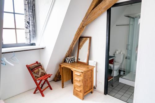 een badkamer met een houten dressoir en een spiegel bij Maison 5 in Souvigny