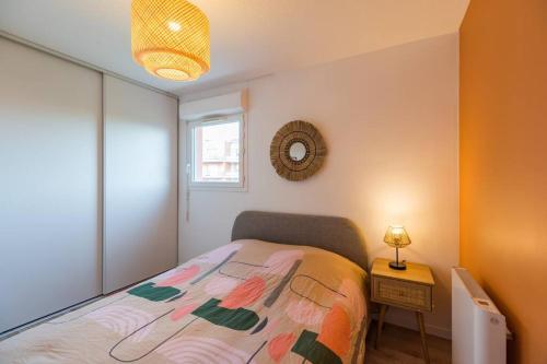 a bedroom with a bed and a lamp and a window at Appartement neuf proche Guingamp in Ploumagoar