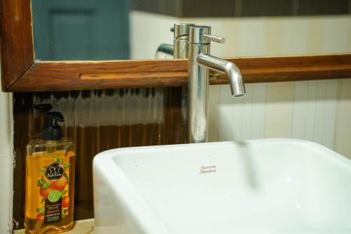a sink with a faucet and a bottle of soap at Ripple Beach Inn in Hulhumale