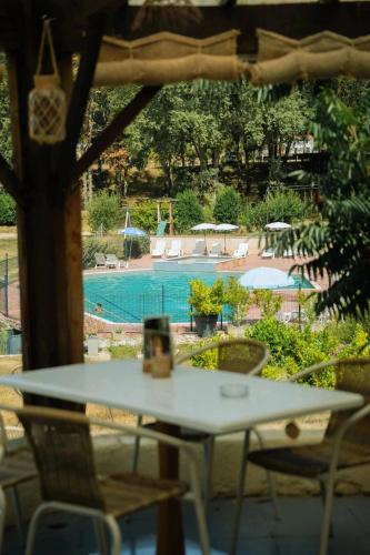 a table and chairs with a view of a swimming pool at ZEcamping 3 étoiles vue lac environnement calme in Douville