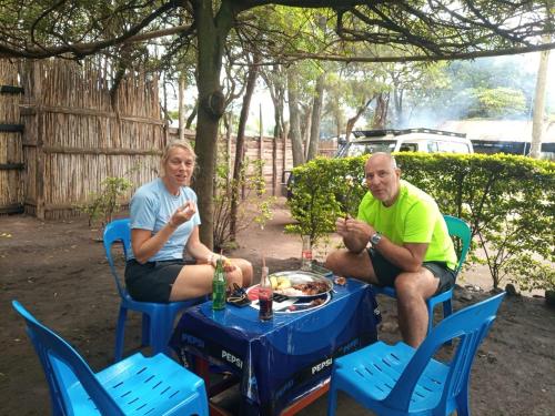 two people sitting at a table with a picnic table at Blue Star Homestay in Kapchorwa