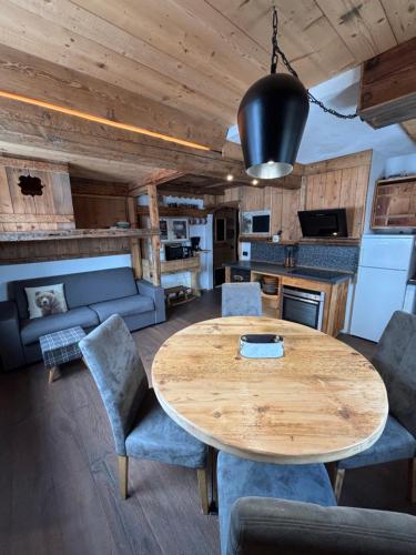 een keuken en woonkamer met een houten tafel en stoelen bij La Tana dell'Orso in Campitello di Fassa
