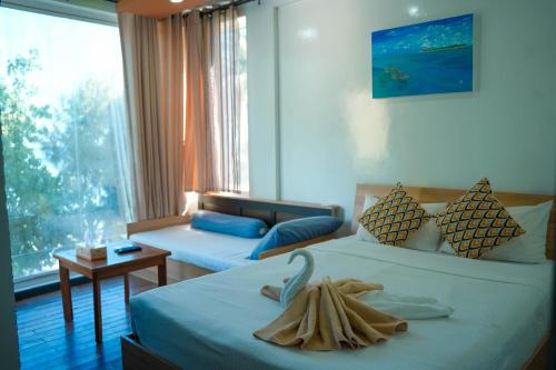 a hotel room with two beds and a couch at Ripple Beach Inn in Hulhumale