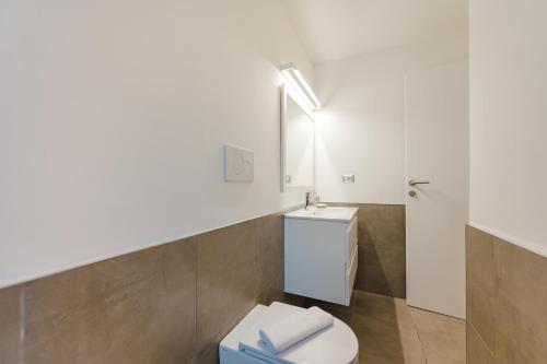 une salle de bains blanche avec toilettes et lavabo dans l'établissement Caneve Home - 15 min from Venice & Wi-Fi, à Venise