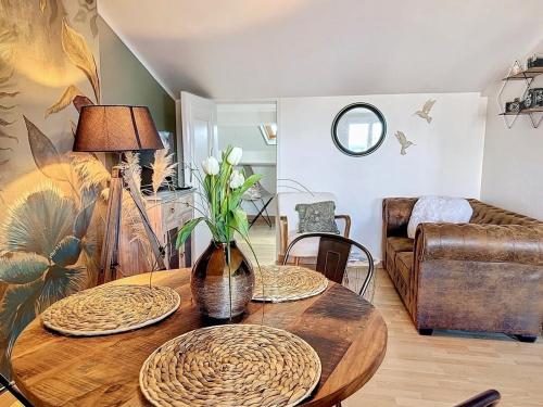 a living room with a table with a vase on it at Escale en bord de mer T3 au coeur de Saint-Quay in Saint-Quay-Portrieux