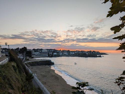 a view of a beach with a sunset in the background at Escale en bord de mer T3 au coeur de Saint-Quay in Saint-Quay-Portrieux