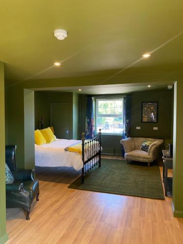 a bedroom with a bed and a couch and a chair at Crowtree Lodge in Louth