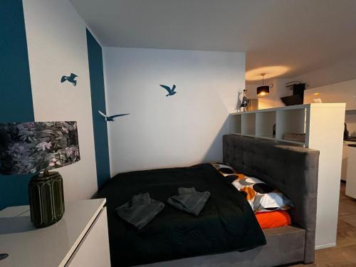 ein Schlafzimmer mit einem Bett mit Vögeln an der Wand in der Unterkunft Studio Mewa in Świnoujście