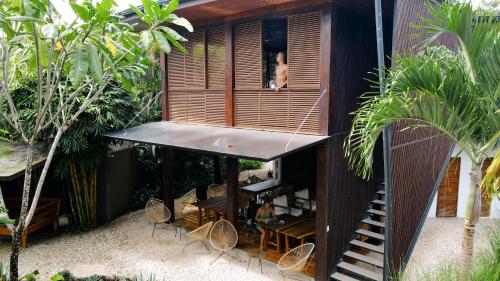 圣塔特蕾莎海滩Outsite Santa Teresa Playa的站在房子窗户上的女人