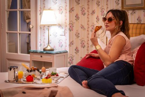 a pregnant woman sitting on a bed eating food at Château De Beauvois - La Maison Younan in Saint-Étienne-de-Chigny