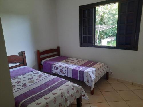 deux lits dans une chambre avec fenêtre dans l'établissement Rancho São Miguel Arcanjo, à Caçapava
