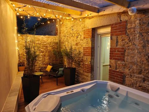 a jacuzzi tub in a brick wall with lights at Charmant Duplex avec jacuzzi Guingamp centre in Guingamp