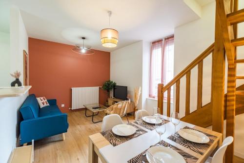 a dining room with a table and a blue chair at Charmant Duplex avec jacuzzi Guingamp centre in Guingamp