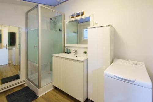 Un baño blanco con lavabo y ducha. en La Maison POP, Centrale, Déco Branchée, Netflix, en Amiens
