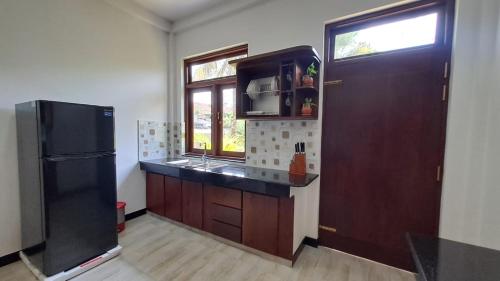 PamunugamaにあるMario Ocean Viewのキッチン(黒い冷蔵庫付)、窓が備わります。