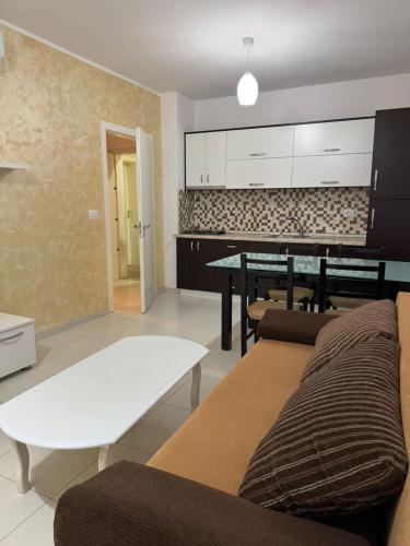 a living room with a couch and a table at Shengjin apartaments kozmai in Shëngjin