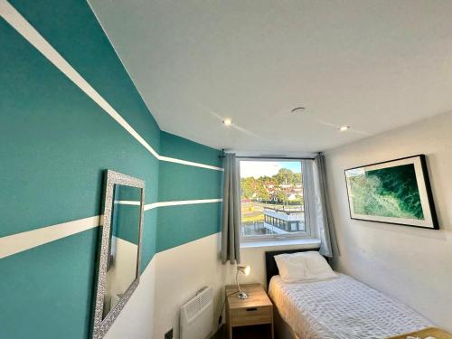 伊登2BR Furnished l Wi-Fi l Parking in Leeds的一间有床和窗户的小房间