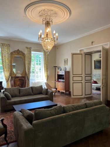 a living room with two couches and a chandelier at Demeure 13 personnes au Centre ville de Ruffec in Ruffec
