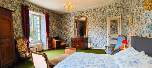 a bedroom with a bed and a room with wallpaper at Demeure 13 Personnes Au Centre Ville De Ruffec in Ruffec
