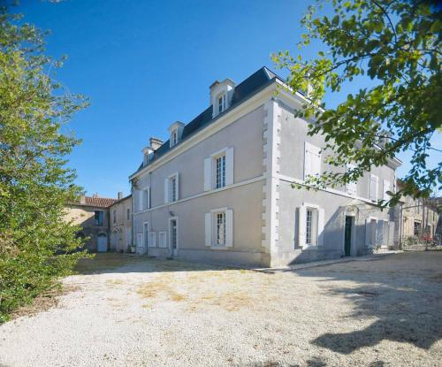 a large white house with a tree in front of it at Demeure 13 Personnes Au Centre Ville De Ruffec in Ruffec