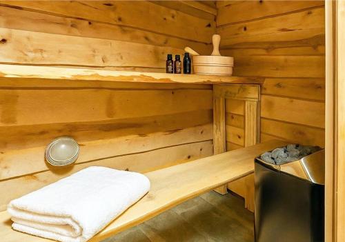 a wooden cabin with a bench and towels in it at Otepää Holiday House with Sauna, Tehvandi Ski Jump View in Otepää