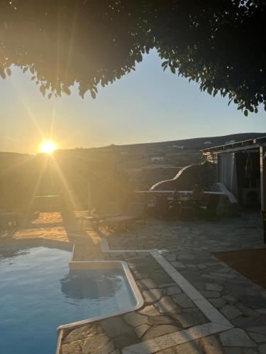 a pool with the sun setting in the background at Casa Paros in Parikia
