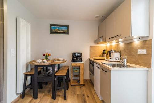 a small kitchen with a table and a counter top at Havre de paix proche de la mer, pointe de Pors Pin in Plouézec