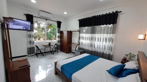 PamunugamaにあるMario Ocean Viewのベッドとテーブルと窓のある寝室