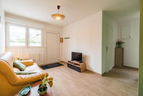 a living room with a couch and a television at Le T2 Zen de Guingamp confort au coeur de la ville in Guingamp