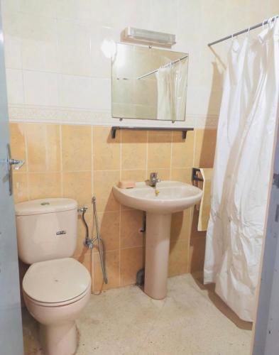 ein Badezimmer mit Toilette, Waschbecken und Spiegel in der Unterkunft Lala Khnata in Temara