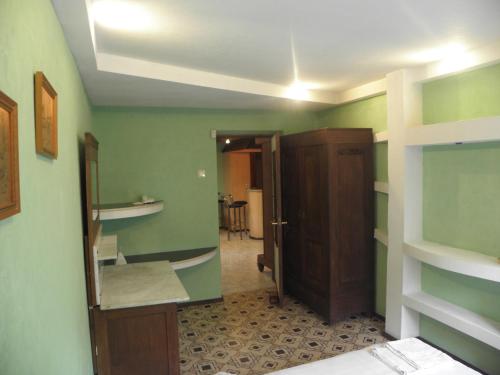 Habitación con paredes verdes y espejo. en Apartament Erfolg 6, en Daugavpils