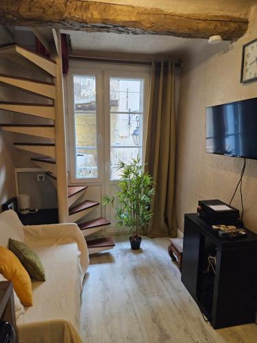 a living room with a couch and a large window at T2 charmant avec mezzanine au cœur d'Aix in Aix-en-Provence