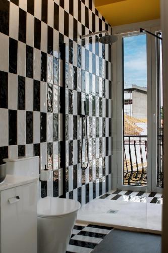 a bathroom with a black and white tile wall at Glória Suites Hotel by Succeed in Lisbon