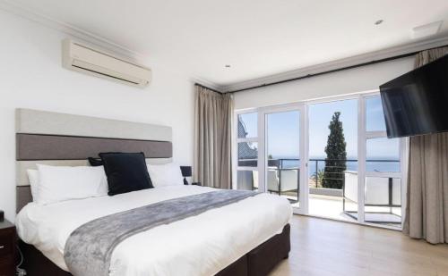 een slaapkamer met een groot bed en een groot raam bij CAPE20 Villa in Kaapstad