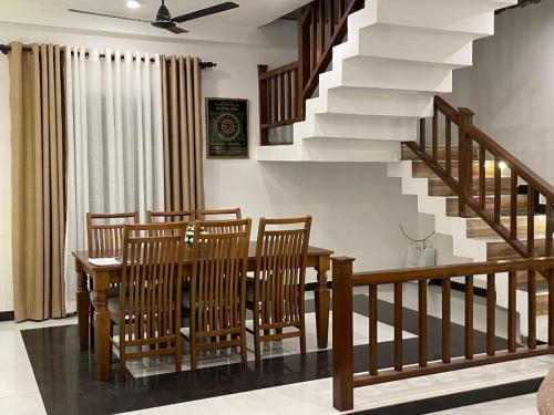 ein Esszimmer mit Tisch und Stühlen und einer Treppe in der Unterkunft Delight Villa - Ahangama in Ahangama