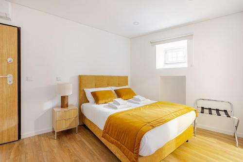 a bedroom with a large bed with a yellow blanket at Stay In Vila Real Apartments in Vila Real