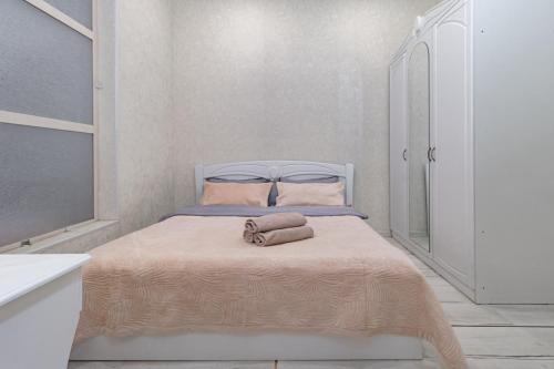 ein kleines Schlafzimmer mit einem Bett mit einem Handtuch darauf in der Unterkunft Трех комнатные апартаменты в новом доме рядом с Батырмол in Pawlodar