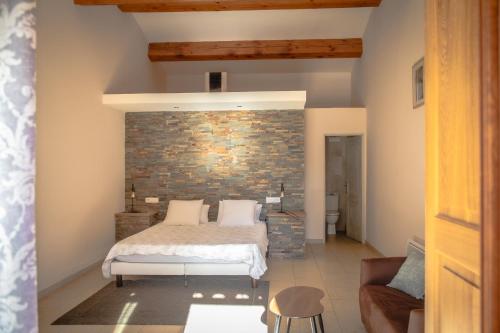 a bedroom with a bed and a brick wall at Les Hauteurs du Luberon in Caseneuve