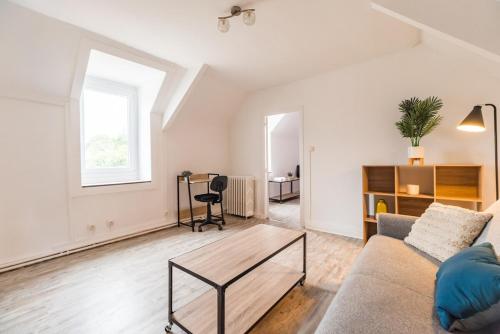 a living room with a couch and a table at Maison Confortable au coeur de Guingamp in Guingamp