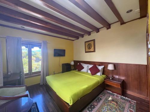 a bedroom with a green bed and a window at Kisa Villa in Thimphu