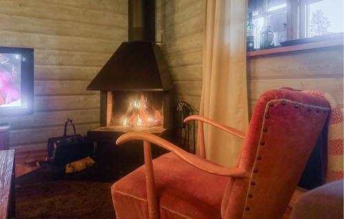 a chair in front of a fireplace with a lamp at Stunning Home In Ljørdalen With Sauna in Ljørdalen