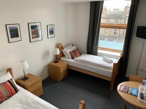 a small bedroom with two beds and a window at Edinburgh Central Accommodation in Edinburgh
