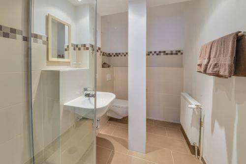 a white bathroom with a sink and a toilet at Bei Meier`s zum weißen Roß in Königslutter am Elm