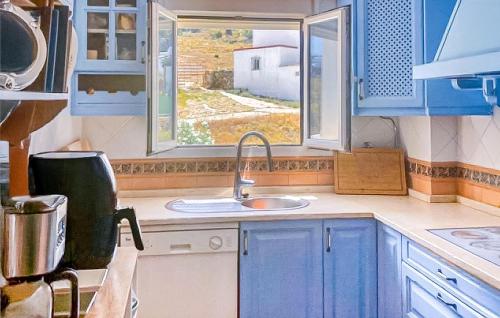 a kitchen with blue cabinets and a sink and a window at 2 Bedroom Awesome Apartment In Facinas - Tarifa in Facinas